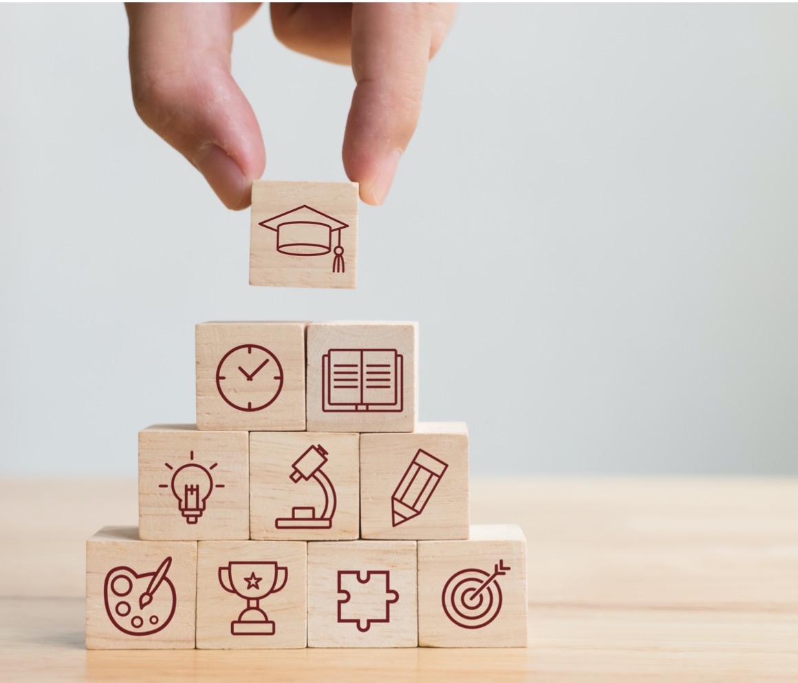 Hand arranging wooden block with various multimedia icons on each one.