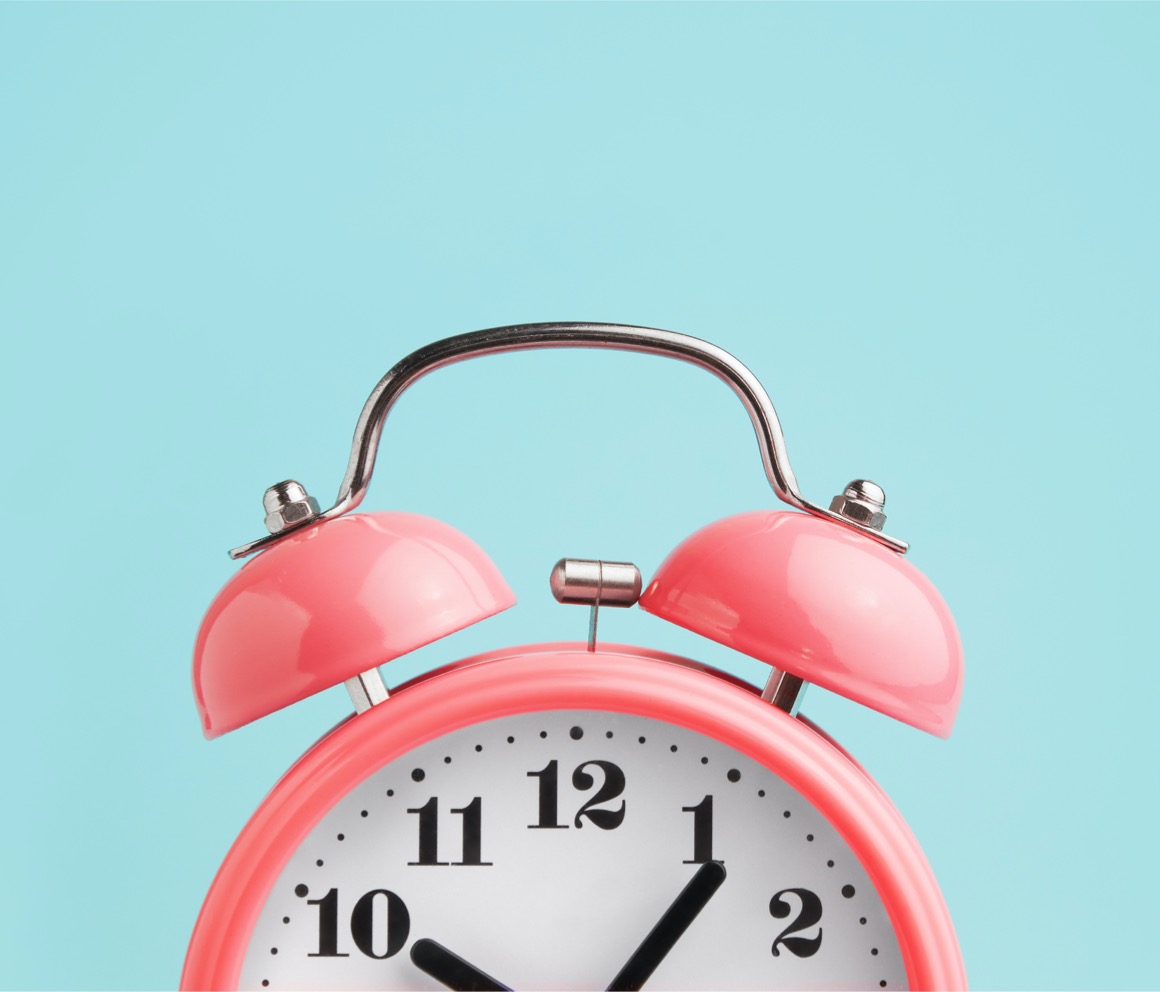 Pink old fashioned clock on a blue background.